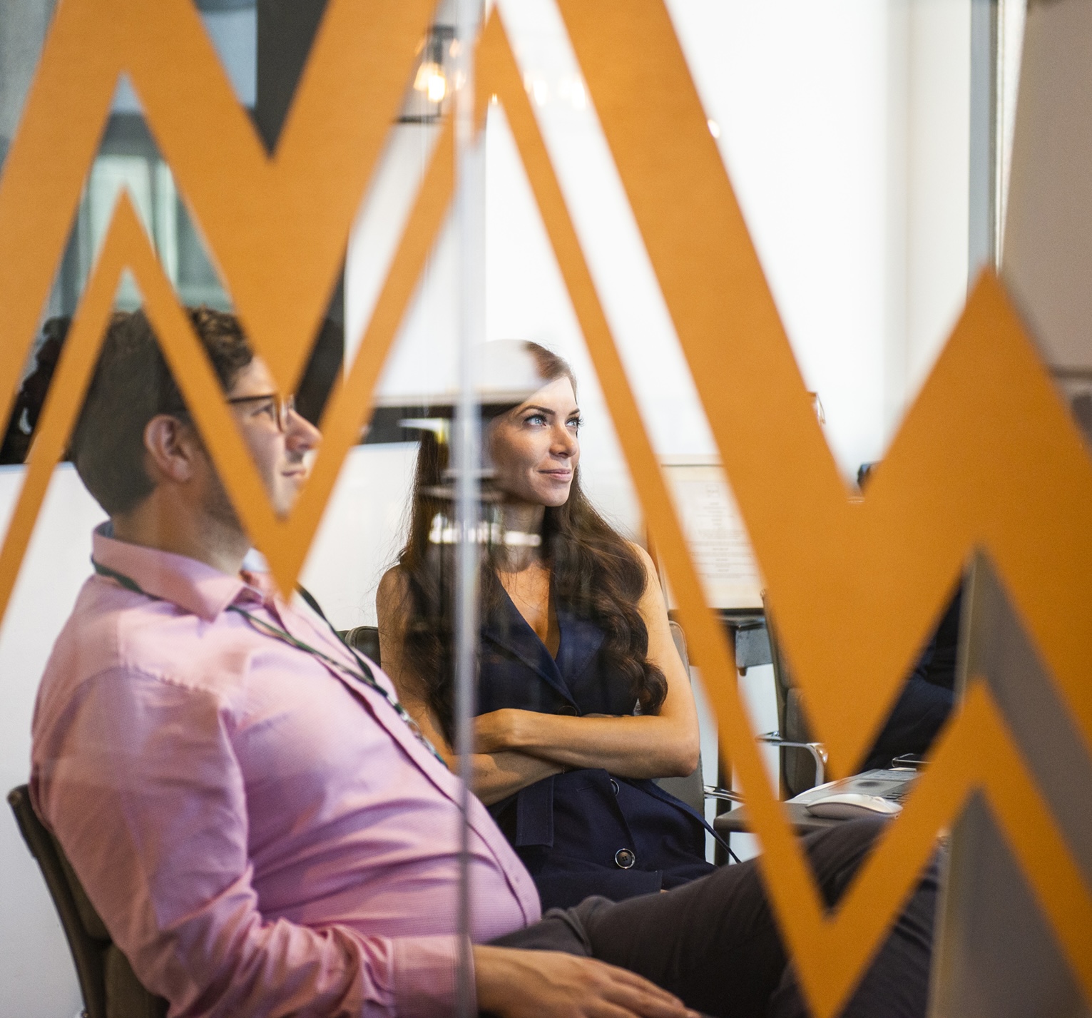 Two consultants have a meeting in a glass-walled room